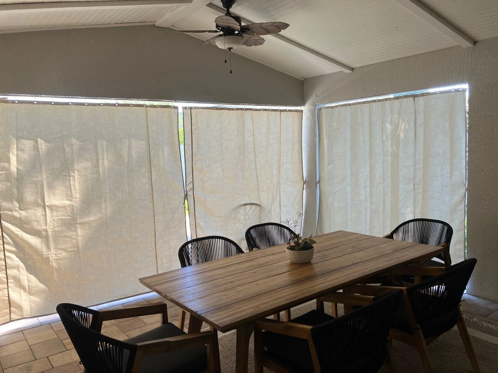 Cream Sunbrella privacy curtains in Florida lanai dining area