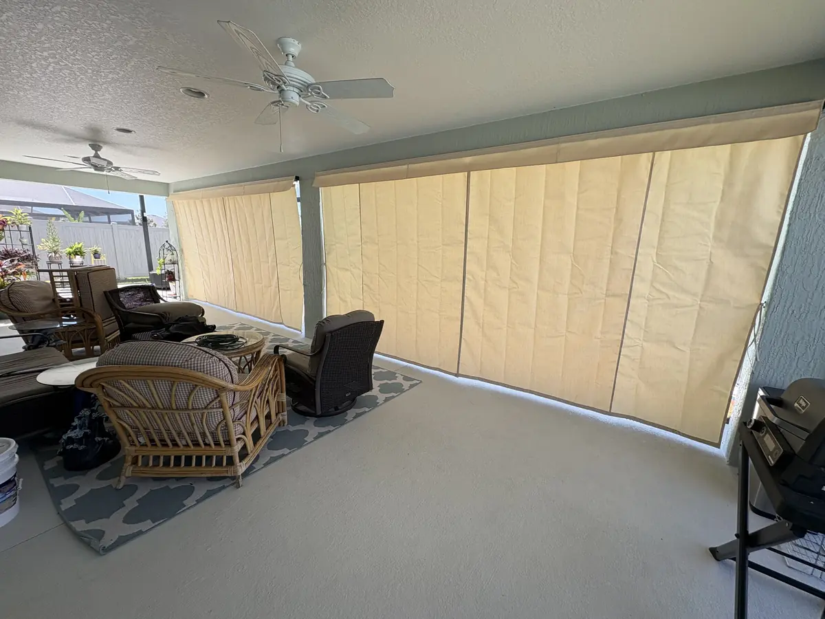 Cream privacy curtains closed around a lanai seating area