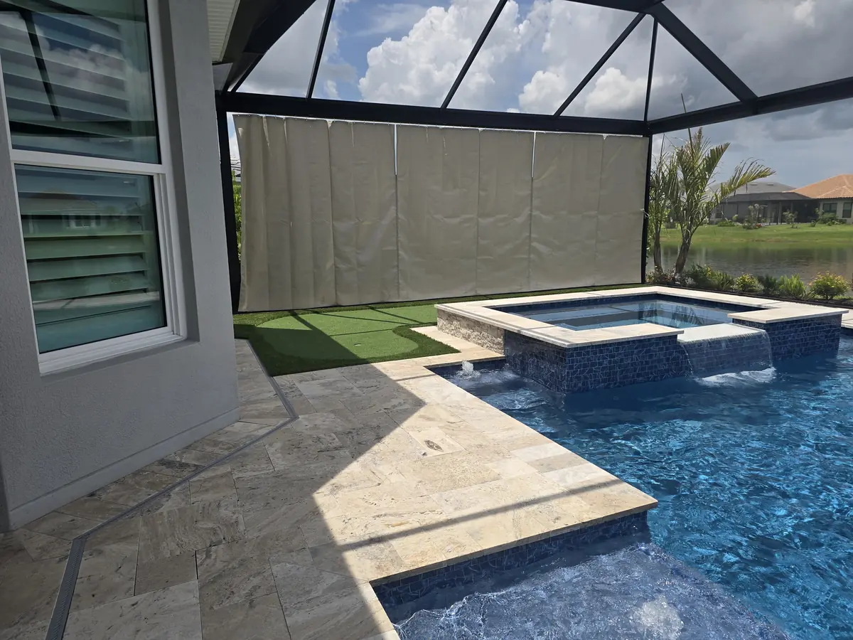 Cream privacy curtain beside a raised spa in a Florida lanai