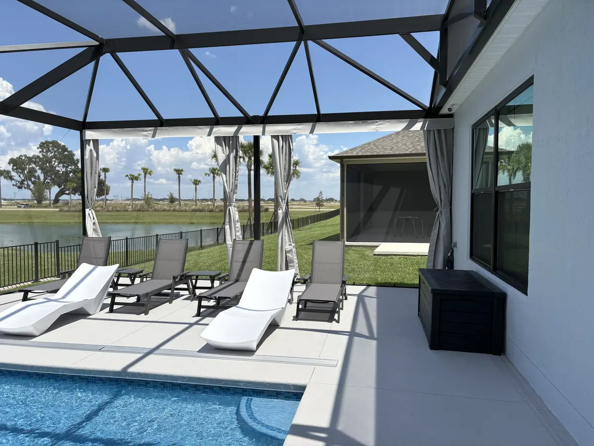 Gray tie-back privacy curtains around a pool deck with white lounge chairs