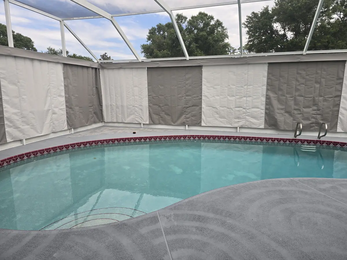 Alternating gray and white privacy curtain panels around a pool in Florida