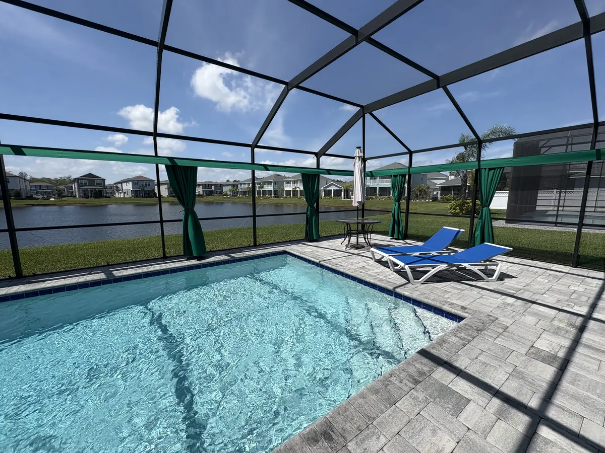 Green tie-back privacy curtains around a pool overlooking a lake in Florida