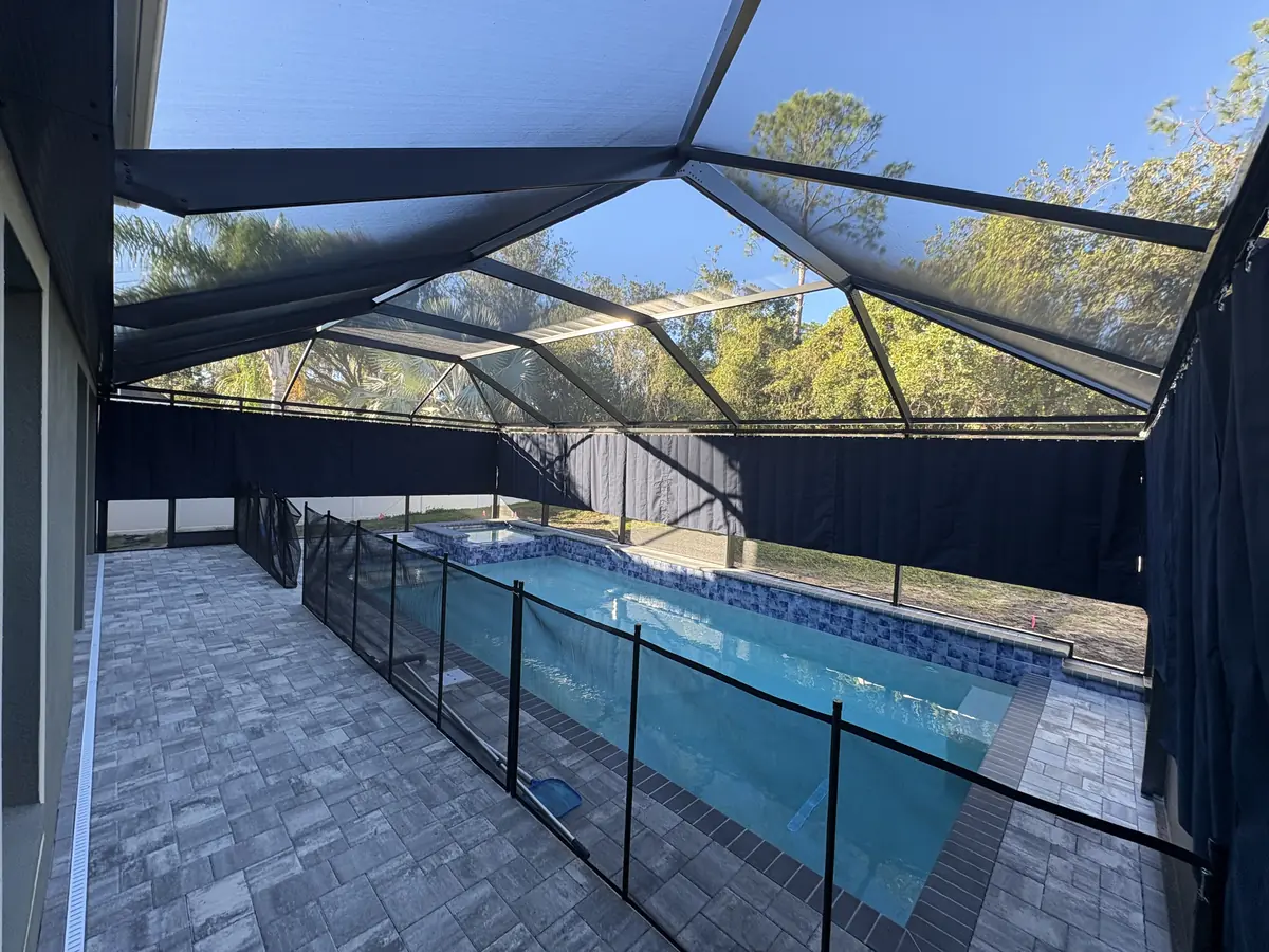 Wide view of navy privacy curtains around a pool with a safety fence