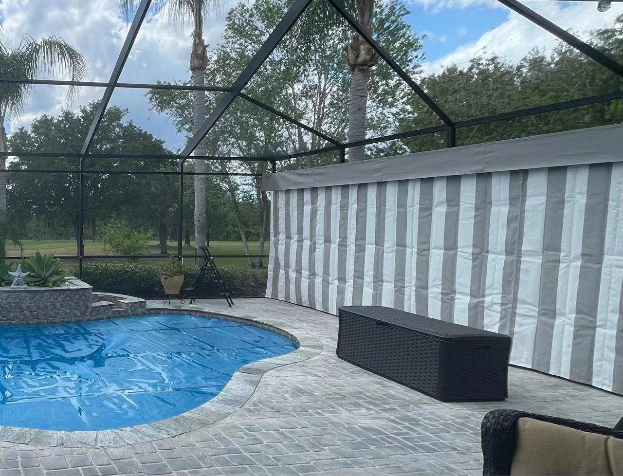Striped Sunbrella outdoor curtains installed in Florida pool cage enclosure