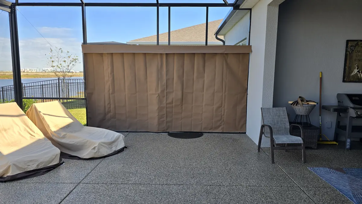 Tan privacy curtains closing off the corner of a lanai beside the house