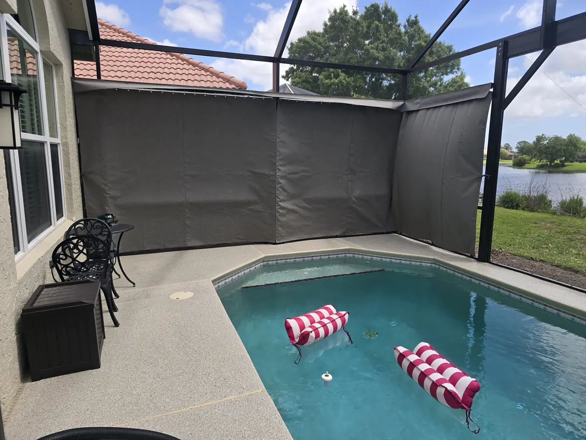 Taupe privacy curtains closing off the corner of a Florida pool cage
