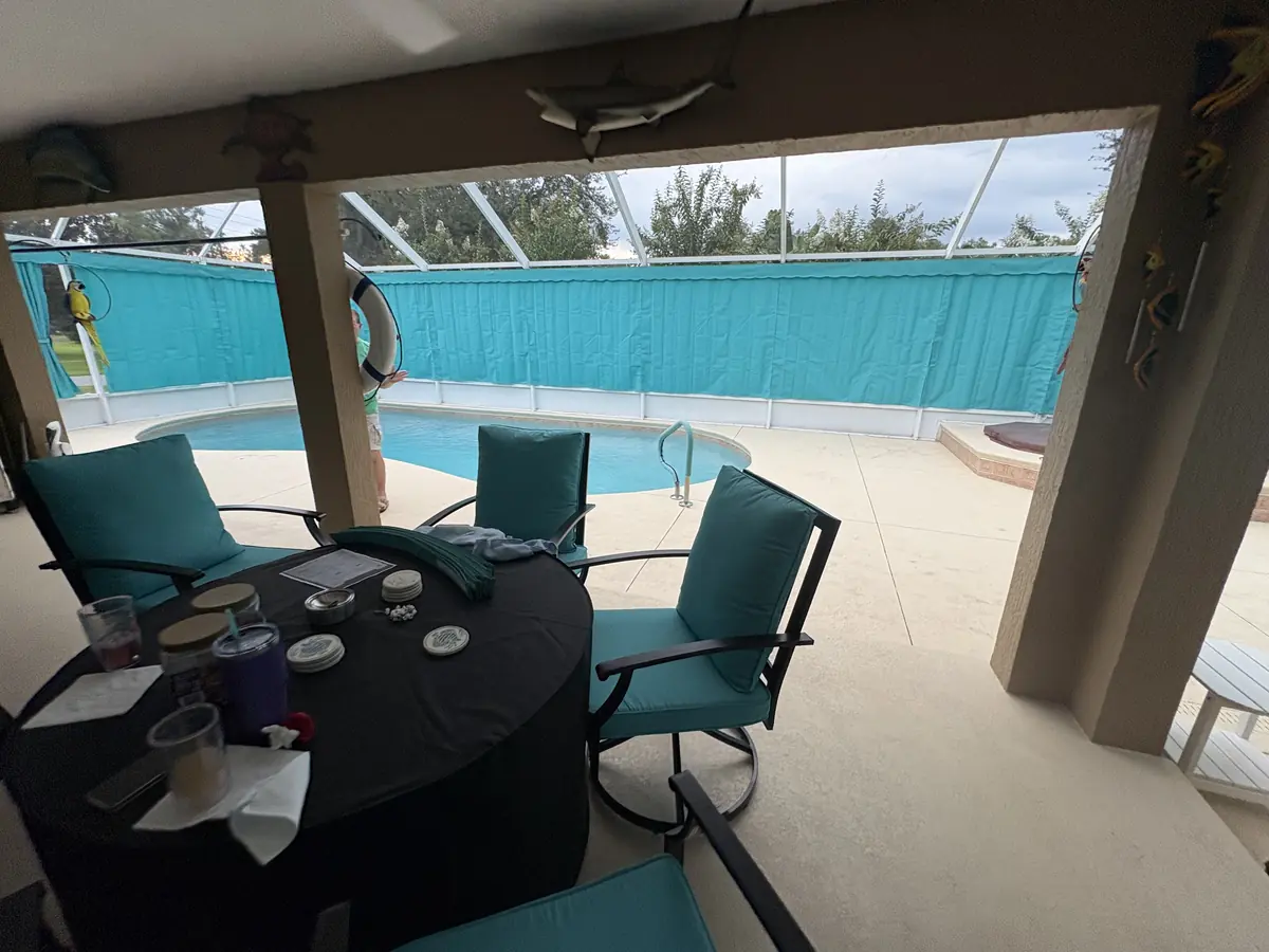 Turquoise privacy curtains behind a lanai seating area with matching chairs