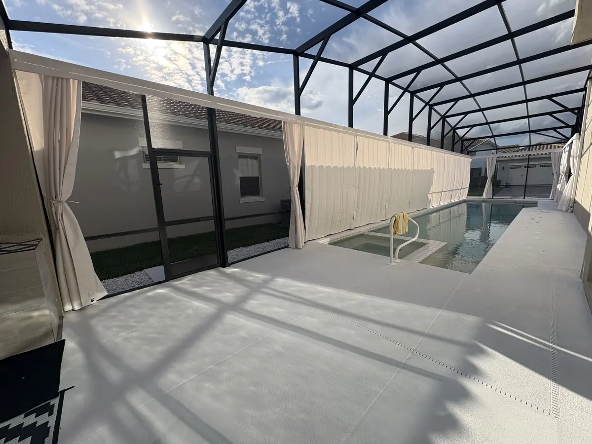 White privacy curtains around a lanai and pool in a Florida screen enclosure