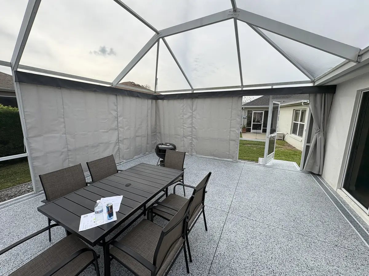 White privacy curtains around a patio dining set in a white screen enclosure