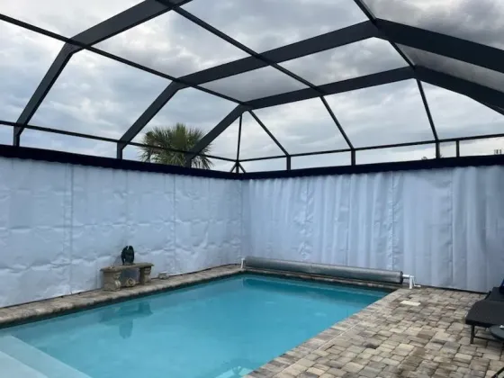 White Sunbrella lanai curtains around pool in Orlando FL screen enclosure