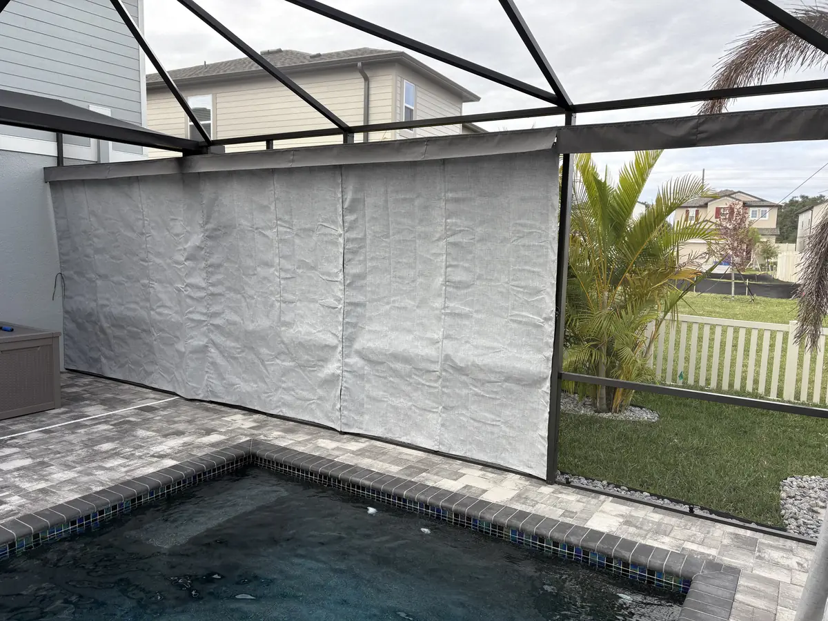 White privacy curtains around a small spa in a Florida screen enclosure