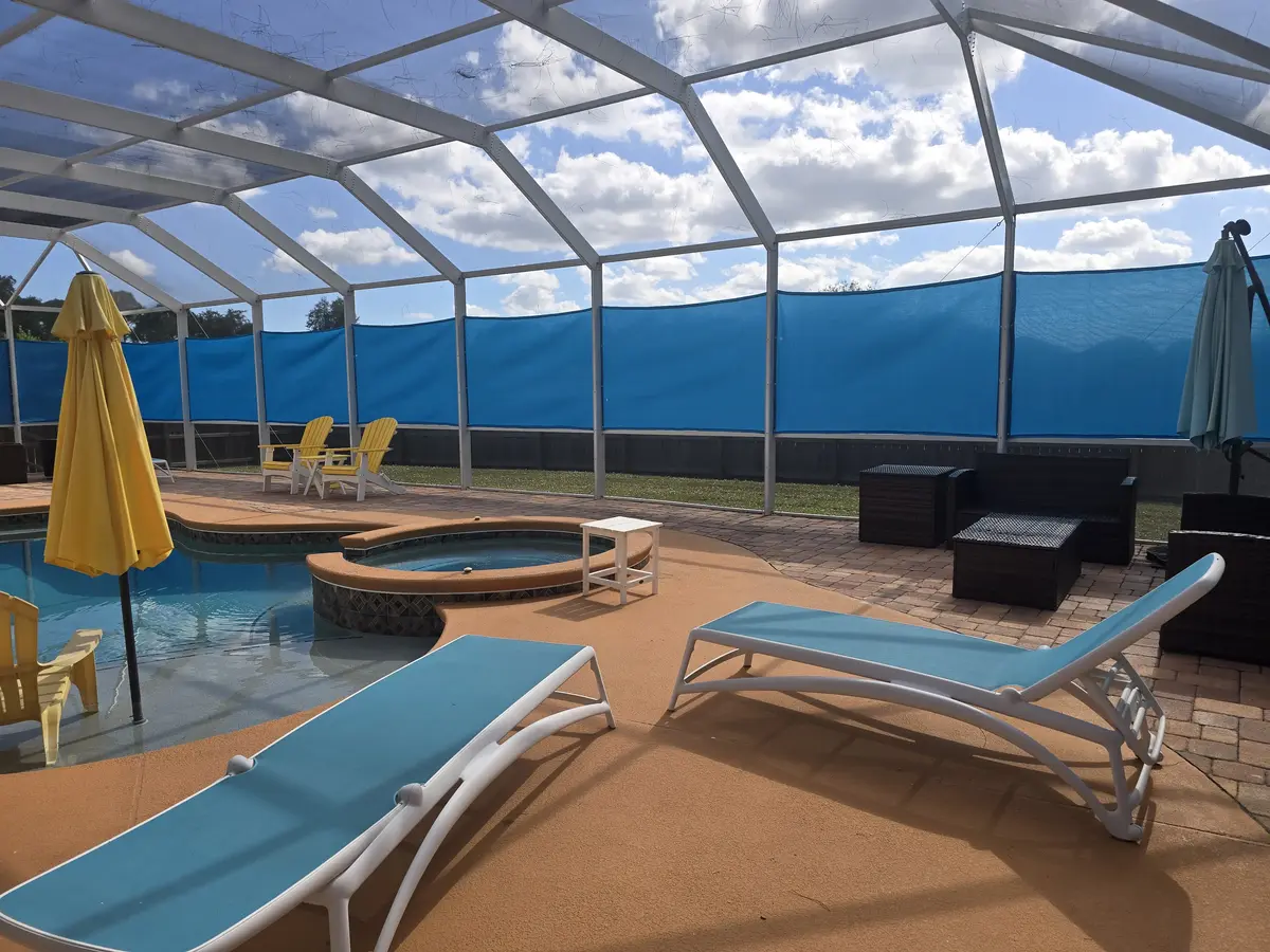 High-density mesh privacy panels with lounge chairs in Florida pool enclosure