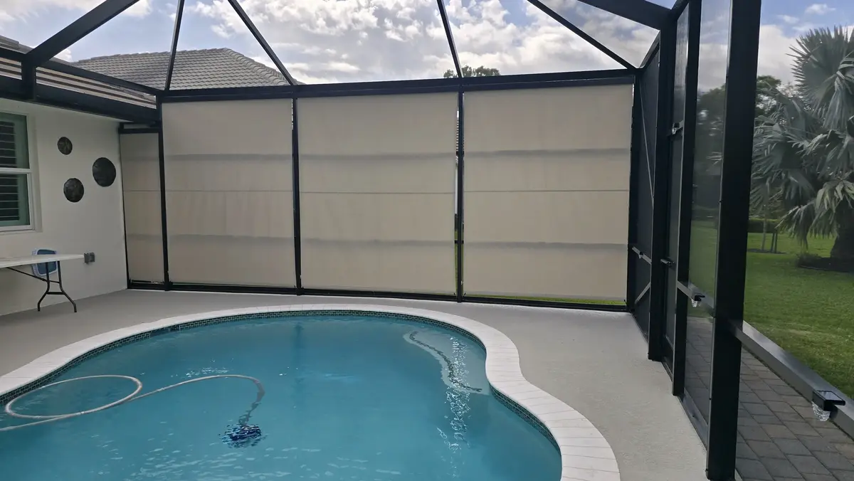 Beige privacy fabric roller shades poolside in Florida screen enclosure