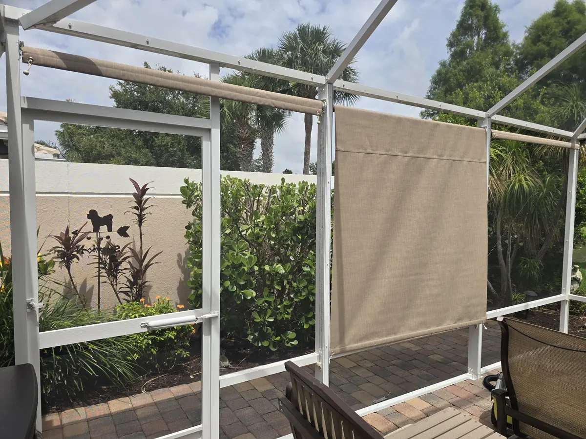 Tan roller shades in the corner of a white screen enclosure lanai