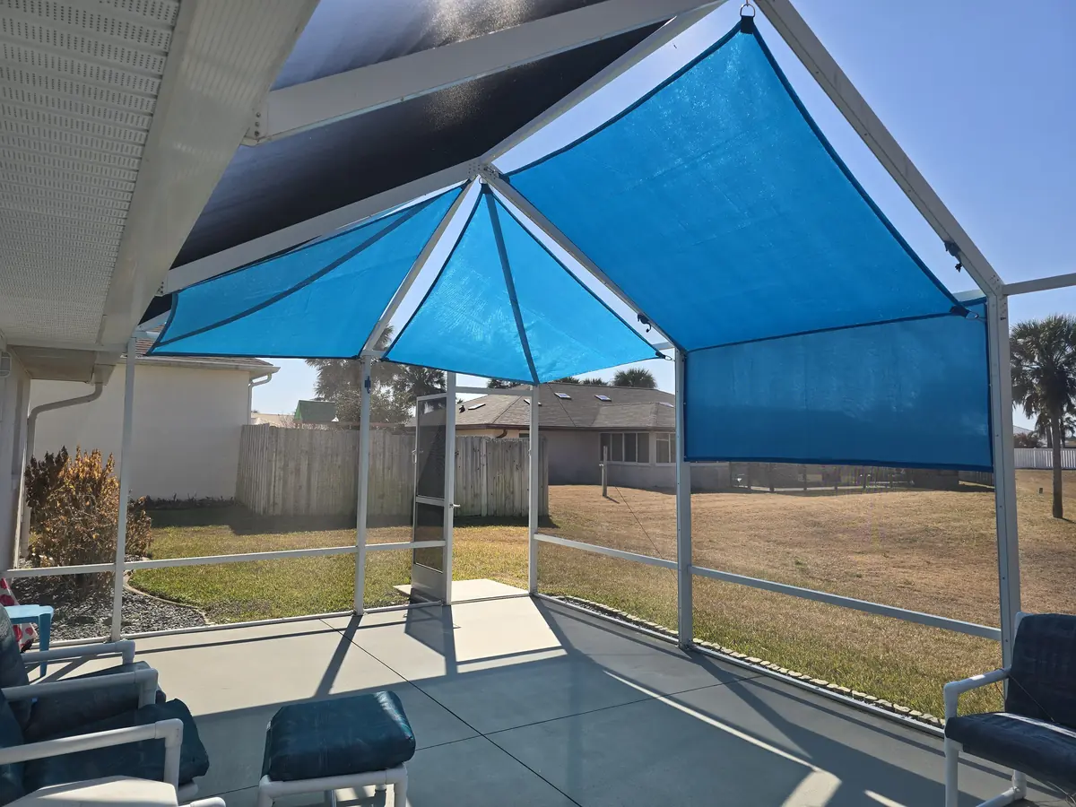 Single blue shade sail in the corner of a Florida pool cage next to a paver patio