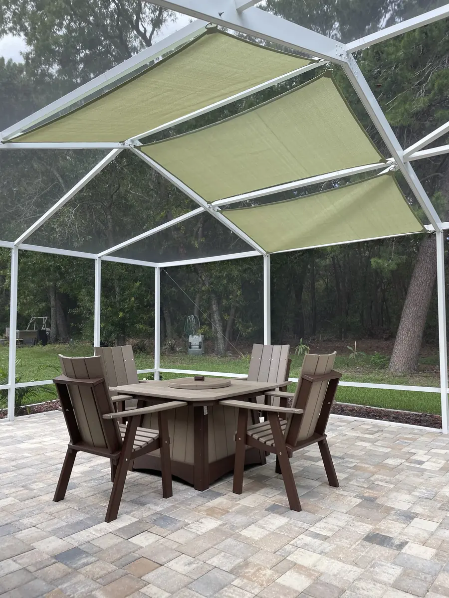 Lime green shade sail over a patio dining set inside a white screen enclosure