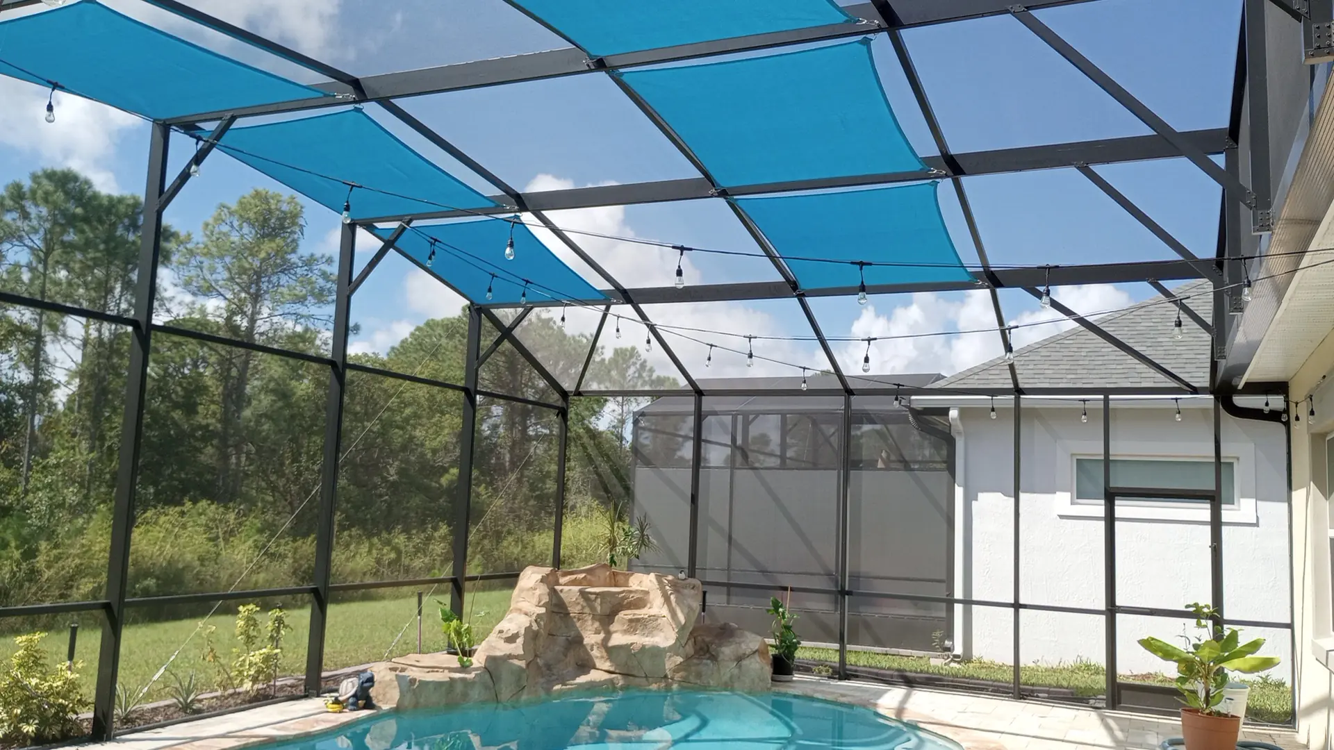 Multi-panel shade sail system in large pool cage