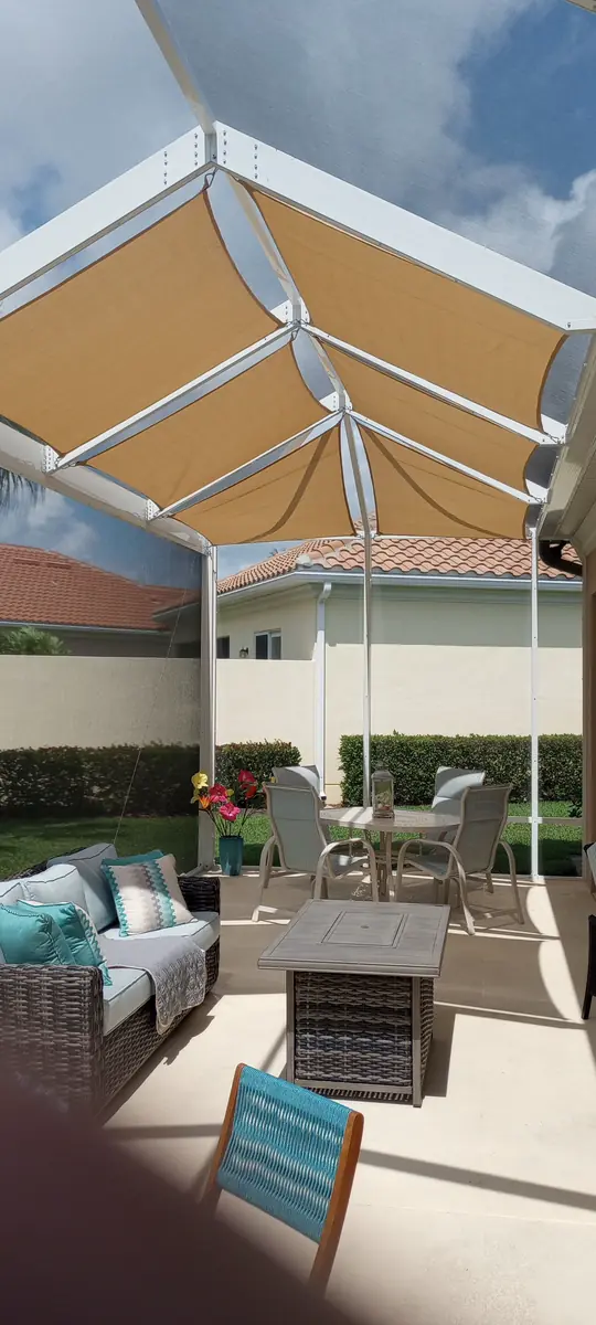 Orange shade sail over a lanai seating area in a white screen enclosure