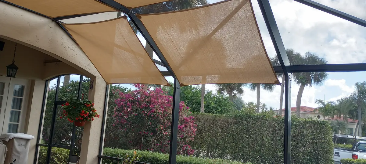 Tan shade sails over a lanai overlooking a golf course in Florida