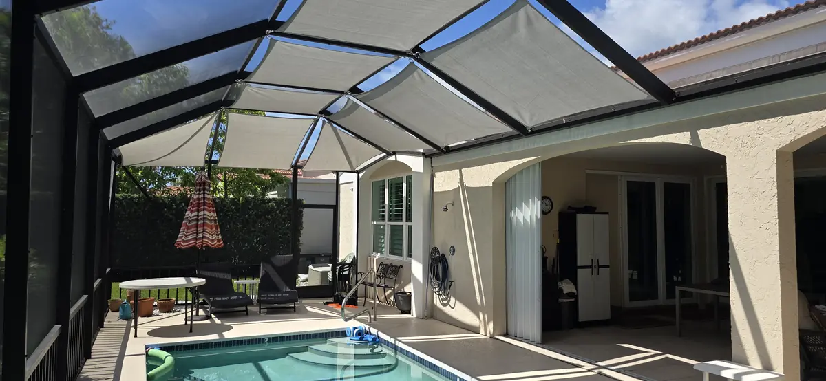 White shade sails over a pool and lanai in a Florida screen enclosure